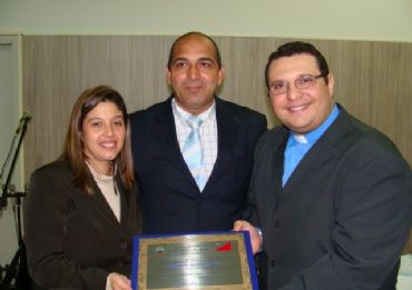 O pastor Julio Roque e sua esposa recebem das mãos do vereador Carlão do JC a placa em homenagem à Comunidade Apostólica Ágape