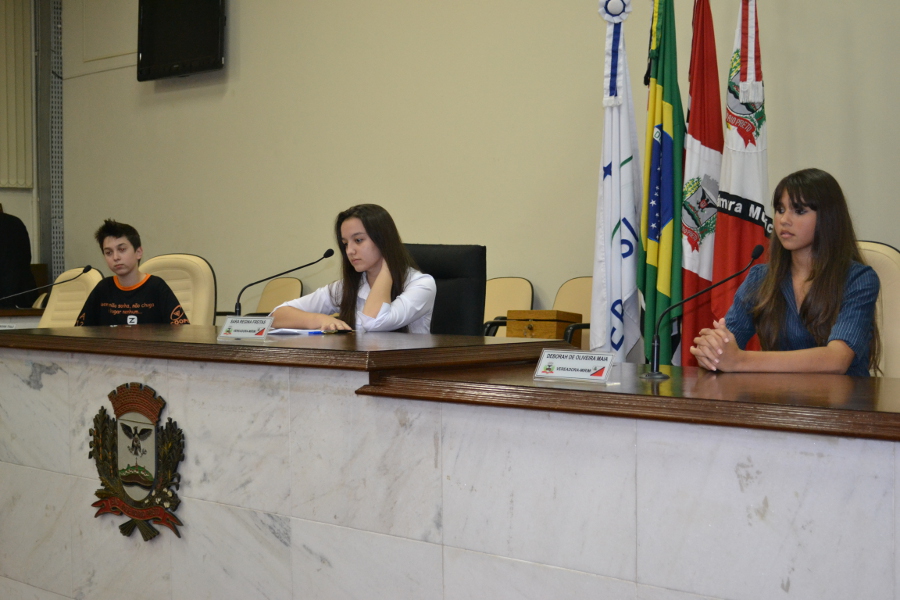 Foto: Suelen Tavares/AICM - Imagem da 1ª Sessão Ordinária da Câmara Mirim que elegeu a Mesa Diretora: Sara Freitas, presidente da Câmara Mirim (ao centro), Déborah Maia, 1ª secretária (à direita) e Rafael Tfaile, 2º secretário (à esquerda)